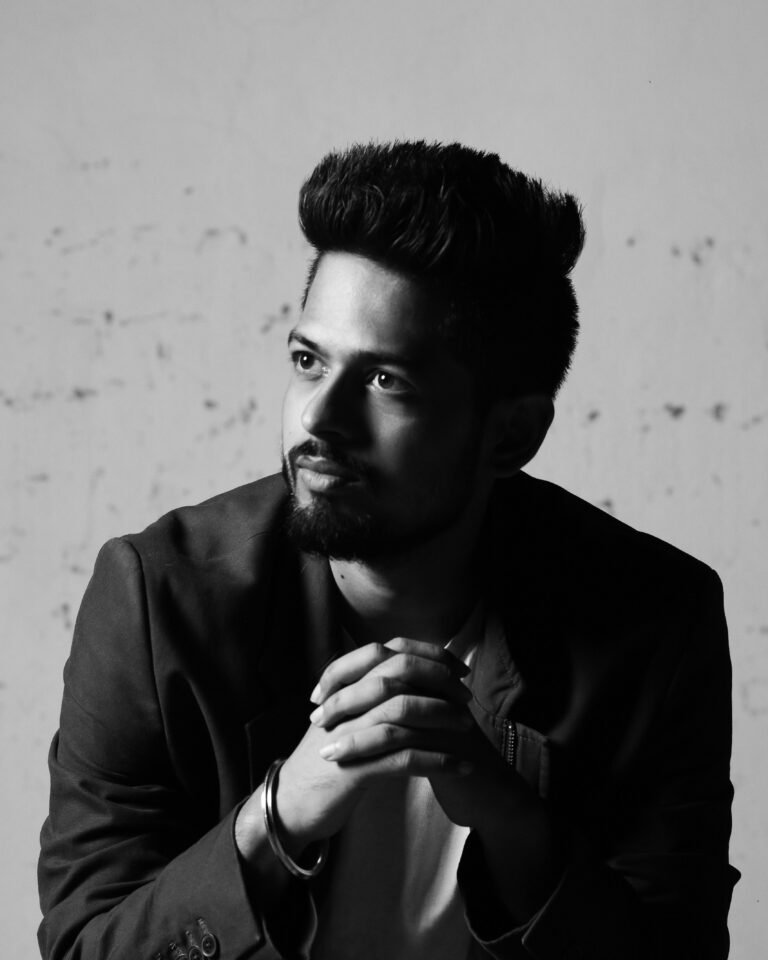 Black and white portrait of a young man with a thoughtful expression and facial hair.